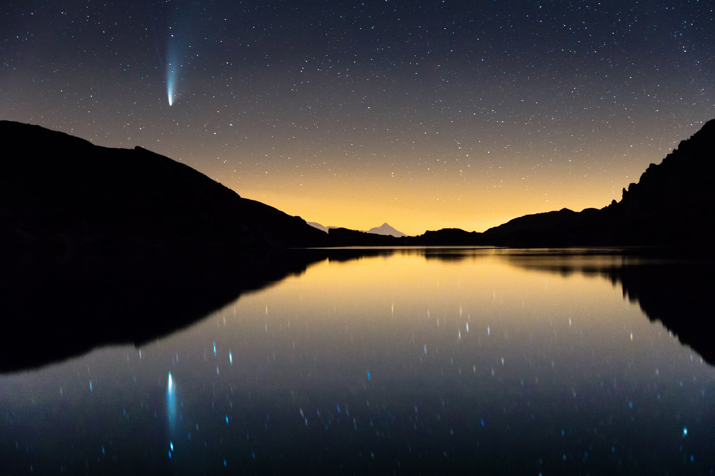 Comet NEOWISE over an alpine lake at night